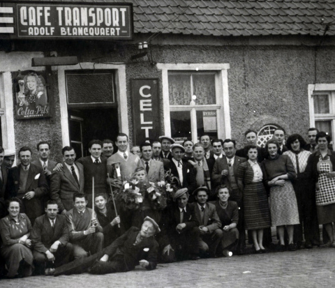 Rechts achter de groep mensen zie je een deel van de Mariakapel in de gevel van café Traansport